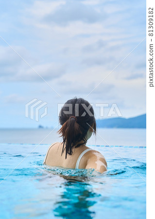 一個女人在室外游泳池游泳的背影 81309182