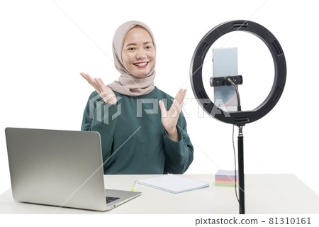 Asian Muslim woman with laptop and mobile phones with lighting equipment make a vlog 81310161