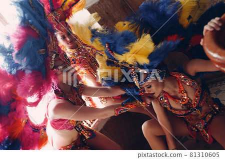 Woman in brazilian samba carnival costume with colorful feathers plumage relax in old entrance with big window 81310605
