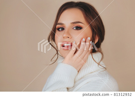 Young woman covering face with sweater collar 81312932