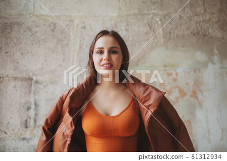 Cheerful stylish woman near weathered wall Cheerful stylish woman near weathered wall 81312934