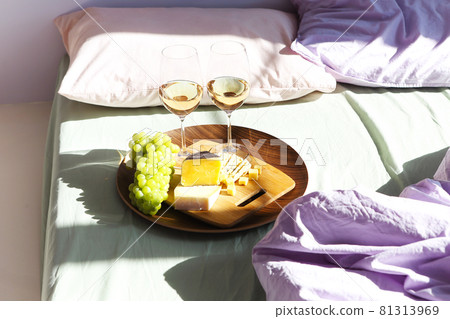 Wine and food on bed in sunny day Wine and food on bed in sunny day 81313969