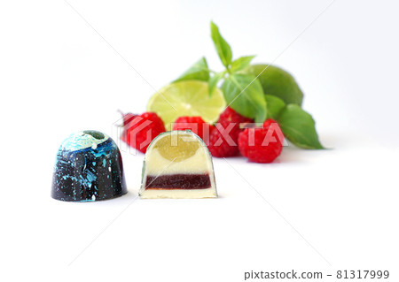 Cutaway chocolate candy. Raspberry, lime and basil on a white background Cutaway chocolate candy. Raspberry, lime and basil on a white background 81317999