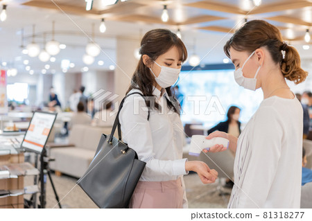 進入共用辦公室時測量體溫的年輕女性 81318277