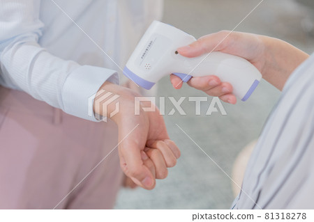 A young woman measuring the temperature on her wrist 81318278
