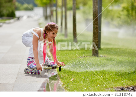 Cheerful little girl on roller skates with braided hair style Cheerful little girl on roller skates with braided hair style 81318742