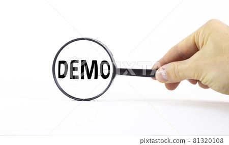 Demo symbol. Magnifying glass with word demo on a beautiful white background. Businessman hand. Business and demo concept, copy space. 81320108