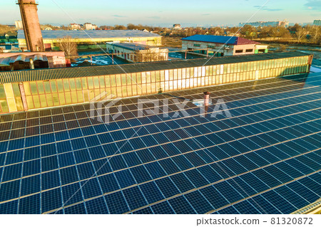 Blue photovoltaic solar panels mounted on industrial building roof for producing clean ecological electricity. Production of renewable energy concept. 81320872