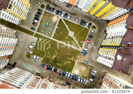Aerial view of parked cars on parking lot between high apartment buildings. Aerial view of parked cars on parking lot between high apartment buildings. 81320974