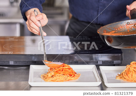 Hand-cooking boy image of a young man wearing an apron with tomato sauce on pasta 81321379