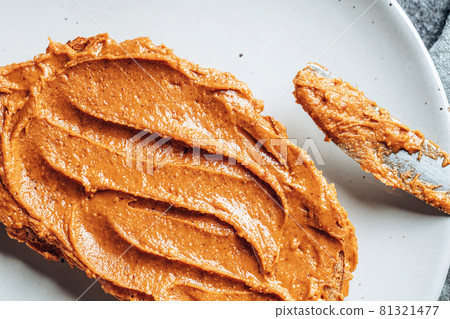 Close-up of peanut butter on toasted bread on a plate. 81321477