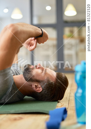 Bearded young man using smartwatch or activity tracker at home 81321520