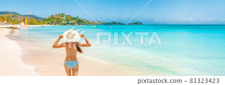 Beach Travel Vacation Holidays Woman walking on Caribbean beach panorama banner background. Rear view of girl tourist in sun hat and bikini on summer holiday vacation destination landscape 81323423