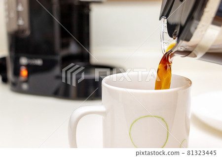 Pour freshly made coffee into a mug from a glass server Pour freshly made coffee into a mug from a glass server 81323445