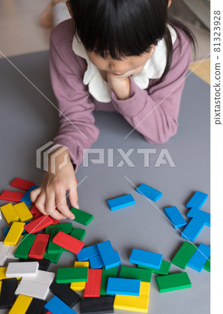 A child playing building blocks dominoes at a summer vacation house A child playing building blocks dominoes at a summer vacation house 81323928