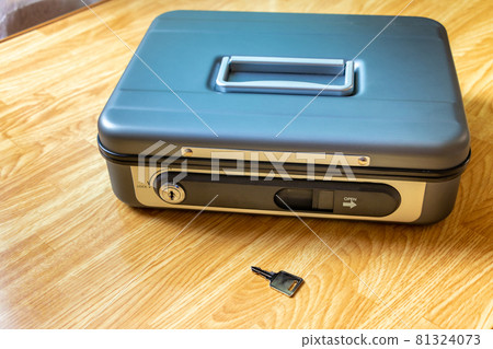 A hand-held safe placed on the desk and its key 81324073