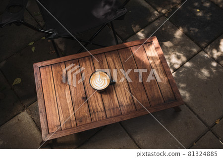 Latte art coffee on wooden table in coffee shop 81324885