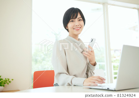 在辦公室使用智能手機的女商人 在辦公室使用智能手機的女商人 81324924