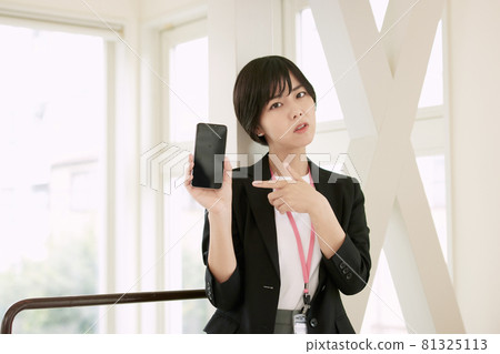 在辦公室使用智能手機的女商人 在辦公室使用智能手機的女商人 81325113