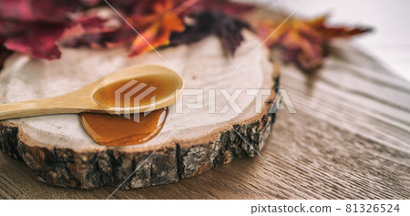 Maple syrup sugar shack cabane a sucre restaurant from Quebec farm maple tree sap famous sweet liquid dripping from wooden spoon on wood log. Rustic sugar shack banner panoramic with red leaves 81326524
