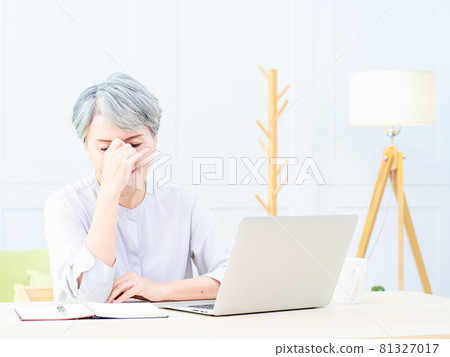 當亞洲的一位成熟女性坐在房間裡寫書和電子產品時,她因疲勞而將目光放在了手上。 當亞洲的一位成熟女性坐在房間裡寫書和電子產品時,她因疲勞而將目光放在了手上。 81327017