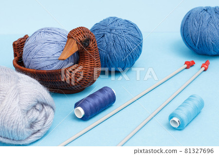 Woolen yarn for knitting. Balls of natural wool yarn and knitting needles 81327696