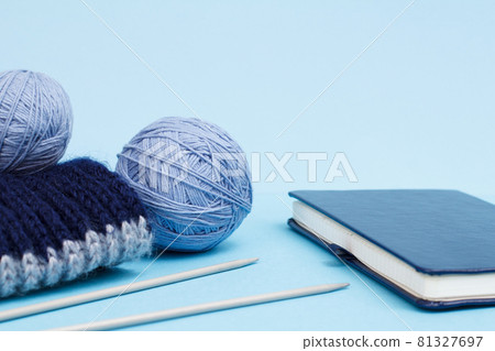 Woolen yarn for knitting. Balls of natural wool yarn and knitting needles 81327697