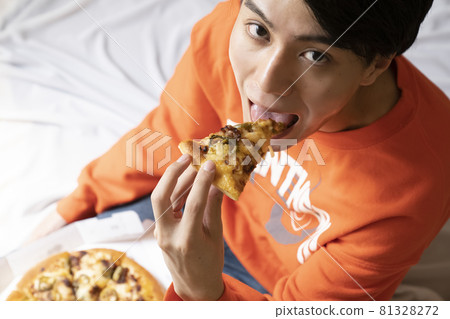 男人在房間裡吃披薩 81328272