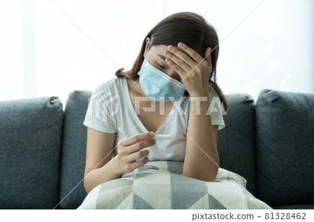Asian young woman teasing a COVID-19 antigen test at home. Asian young woman teasing a COVID-19 antigen test at home. 81328462