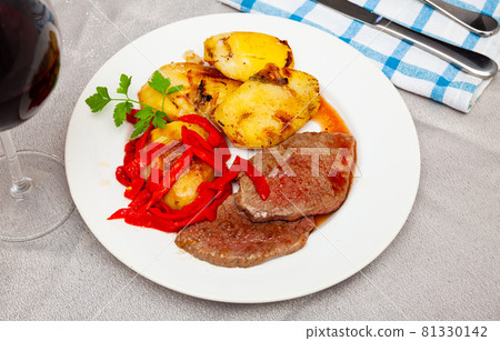 Tasty veal baked with potatoes and peppers served at plate 81330142