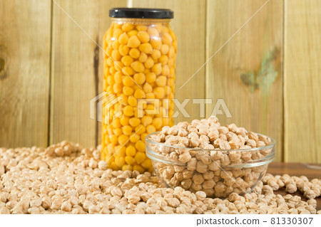 Glass bowl of raw chickpeas on wooden surface. Healthy and nutritious food Glass bowl of raw chickpeas on wooden surface. Healthy and nutritious food 81330307