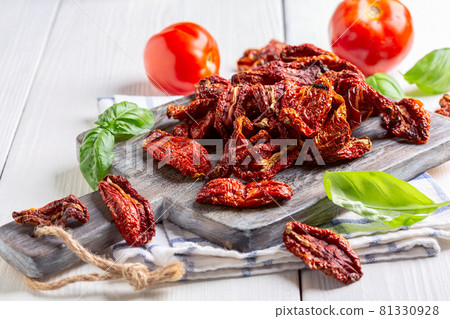 Dried tomatoes and fresh basil. 81330928
