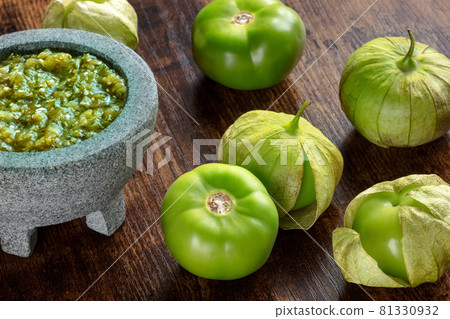 Tomatillos, green tomatoes, with salsa verde, green sauce, in a molcajete Tomatillos, green tomatoes, with salsa verde, green sauce, in a molcajete 81330932