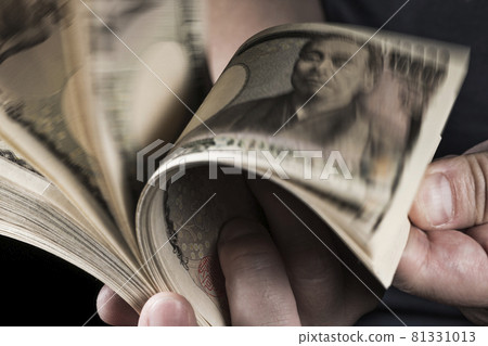 Male hand holding a wad of bills 81331013