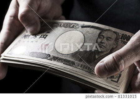 Male hand holding a wad of bills Male hand holding a wad of bills 81331015