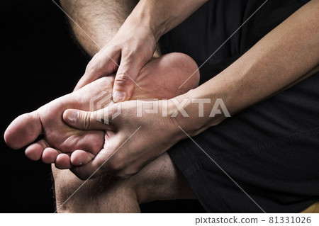 男人的手握著腳底 男人的手握著腳底 81331026