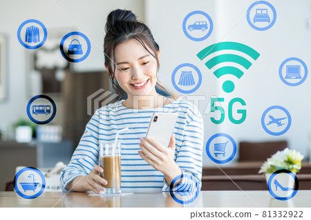 一個年輕的女人,看著一家咖啡館的智能手機 一個年輕的女人,看著一家咖啡館的智能手機 81332922