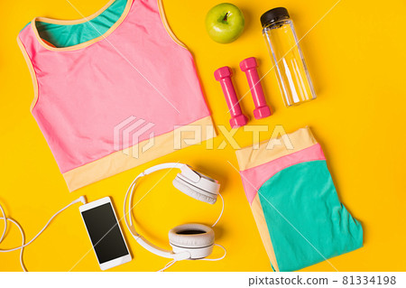 Sport equipment and clothes with mobile phone on yellow background. Top view Sport equipment and clothes with mobile phone on yellow background. Top view 81334198