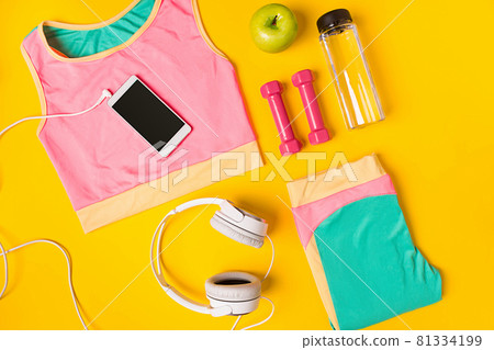 Sport equipment and clothes with mobile phone on yellow background. Top view Sport equipment and clothes with mobile phone on yellow background. Top view 81334199