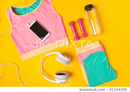 Sport equipment and clothes with mobile phone on yellow background. Top view Sport equipment and clothes with mobile phone on yellow background. Top view 81334200