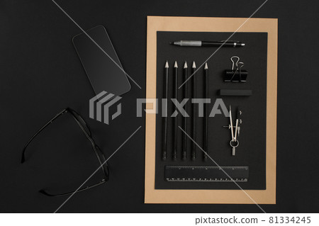 Office desktop with various black objects on background 81334245