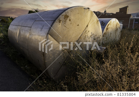 Old steel tanks at sunset 81335804