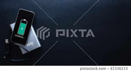Phone power bank. Mobile phone or smartphone battery charging from portable powerbank with white usb cable. External battery for mobile devices with copy space. Phone power bank. Mobile phone or smartphone battery charging from portable powerbank with white usb cable. External battery for mobile devices with copy space. 81336215