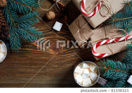 Cocoa with marshmallow, chocolate and spruce branches on a wooden background Cocoa with marshmallow, chocolate and spruce branches on a wooden background 81336321