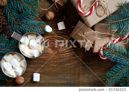 Cocoa with marshmallow, chocolate and spruce branches on a wooden background 81336323