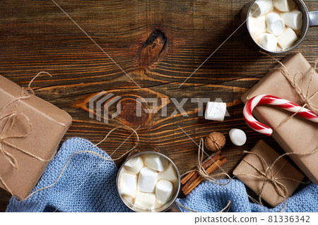 Christmas drink. Mug hot coffee with marshmallow, red candy cane on the wooden background. New Year. 81336342