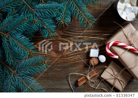 Cocoa with marshmallow, chocolate and spruce branches on a wooden background Cocoa with marshmallow, chocolate and spruce branches on a wooden background 81336347