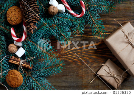 Christmas or New Year background with cookies, spices, cinnamon, nuts and fir tree branch on dark wooden background. Christmas or New Year background with cookies, spices, cinnamon, nuts and fir tree branch on dark wooden background. 81336350