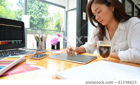 Young female graphic designer using stylus and tablet sketching new art model 81336623