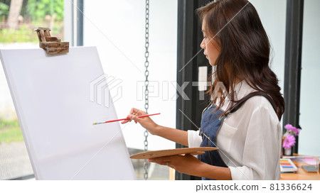 Blank canvas easel mockup for your artwork painting by attractive female artist Blank canvas easel mockup for your artwork painting by attractive female artist 81336624
